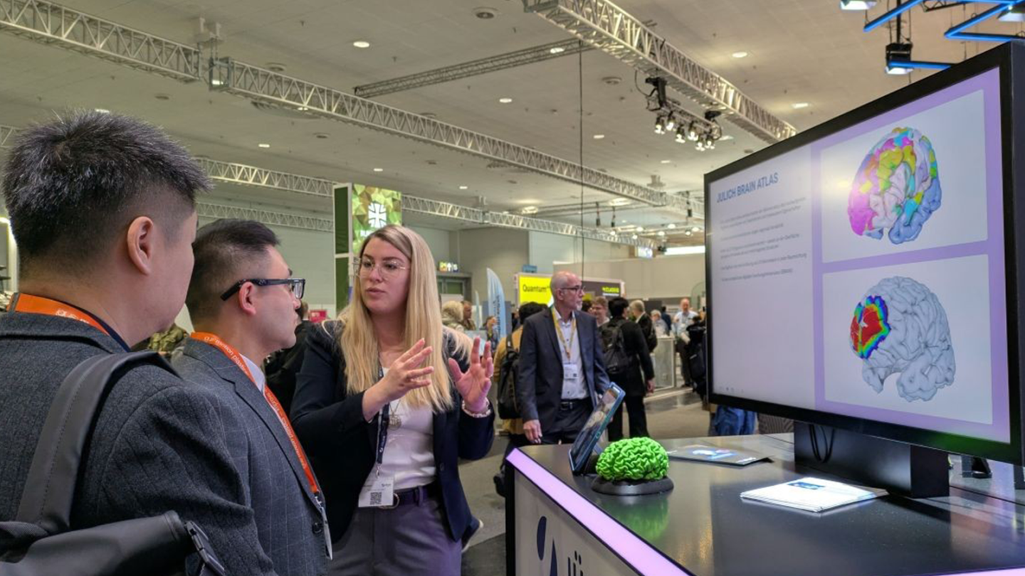 Dr. Kimberley Lothmann presenting the Julich Brain Atlas at the exhibition stand of Forschungszentrum Jülich.