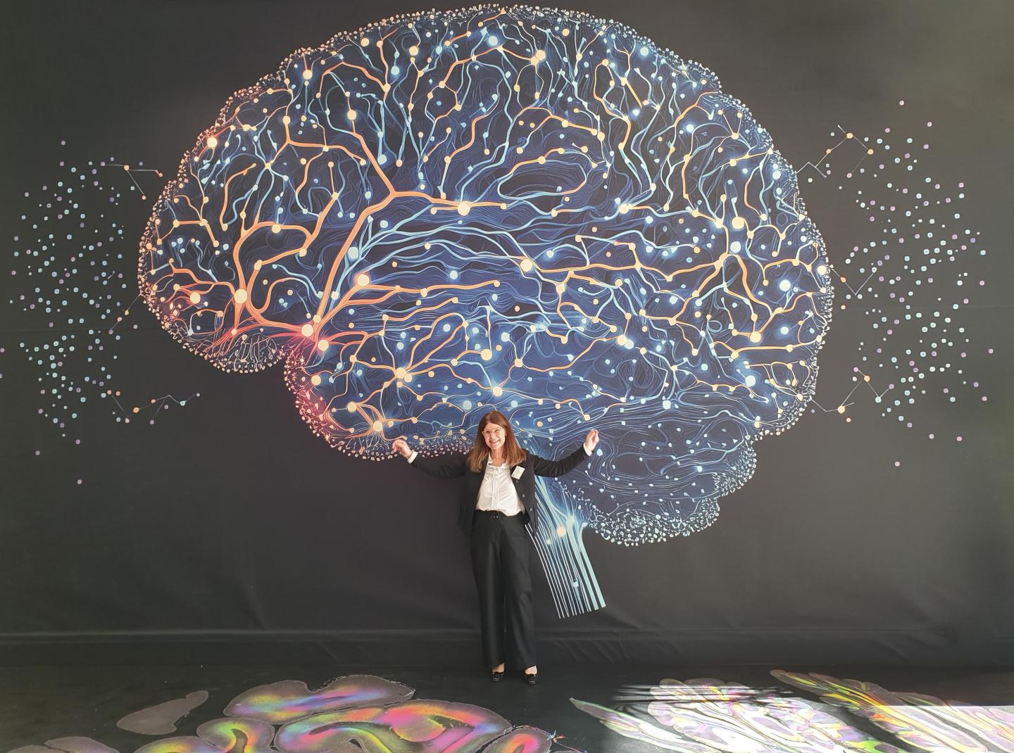 EBRAINS Joint-CEO Katrin Amunts in front of one of the images from the exhibition.