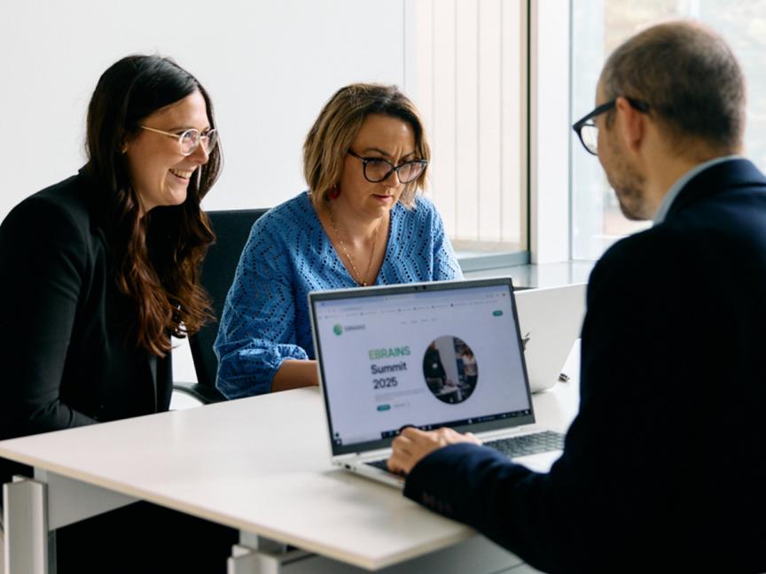Three members of the AISBL staff working together at a desk