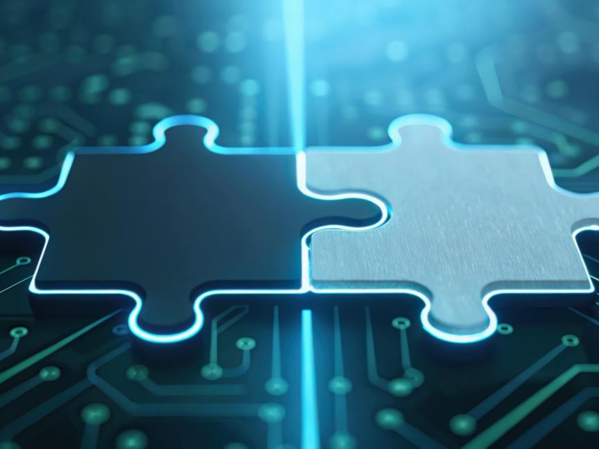 Two pieces of a jigsaw puzzle on a computer chip