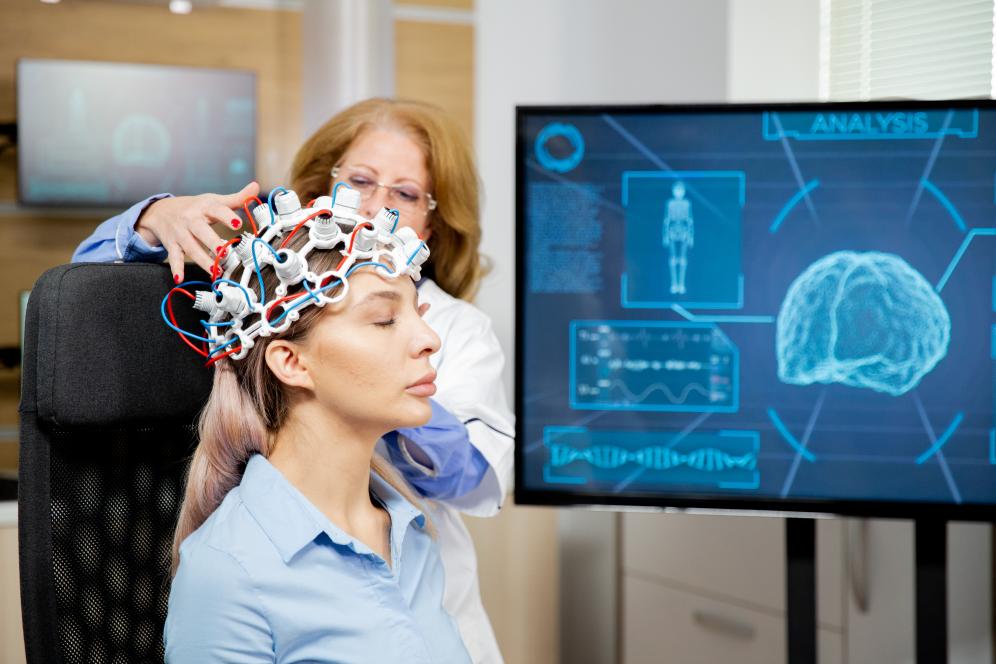 Doctor arranging MRI cap on head of female patient